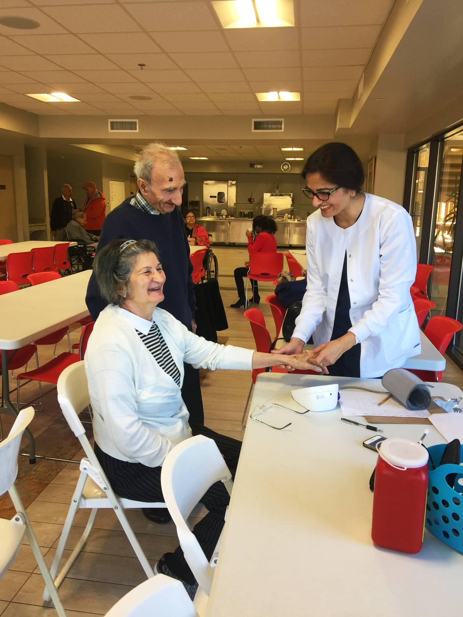 A caregiver checking in on a senior at a community dining hall