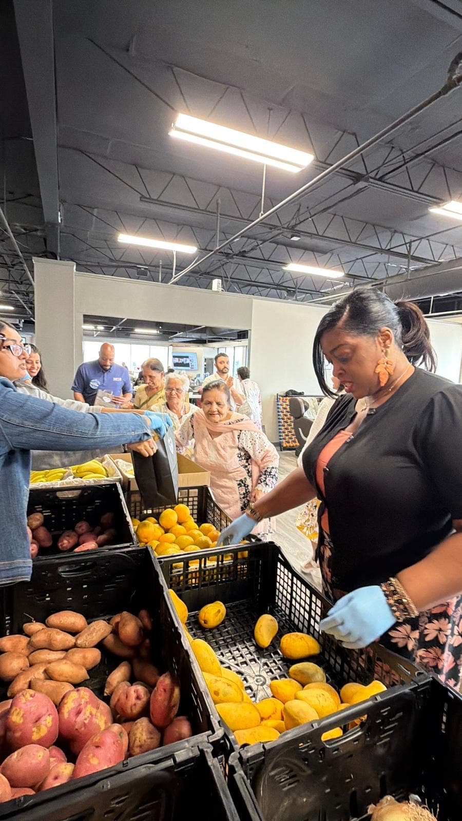 A senior receiving fresh produce at a Seva food pantry distribution